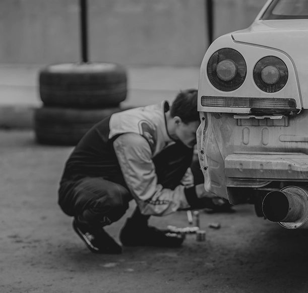 Mechanic working on a car in a garage, mobile view